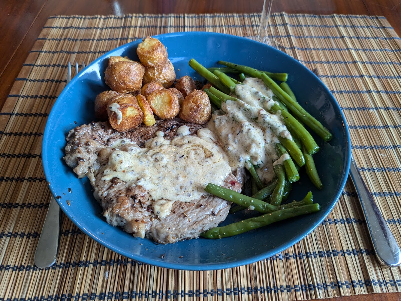 Steak flambé au poivre, patates rôties, haricots vers